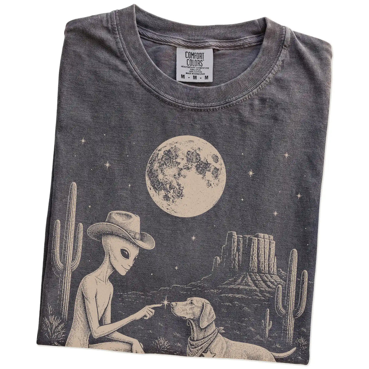 Folded Pepper Comfort Colors® T-shirt showing cowboy alien fist-bumping a vizsla beneath the moon