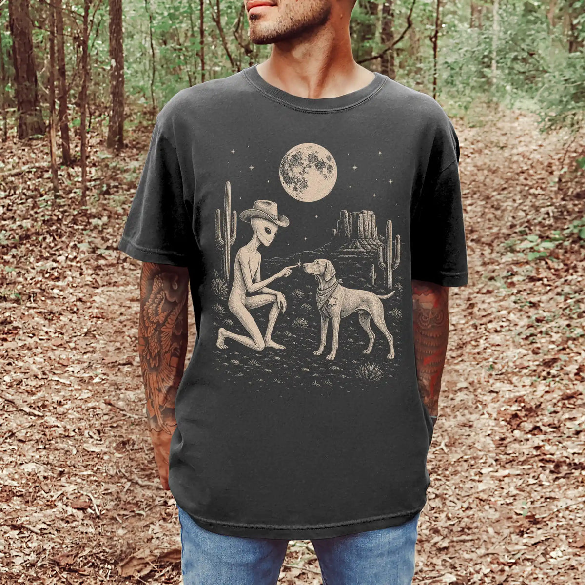 Model wearing a Pepper Comfort Colors® T-shirt with cowboy alien fist-bumping a vizsla beneath the moon