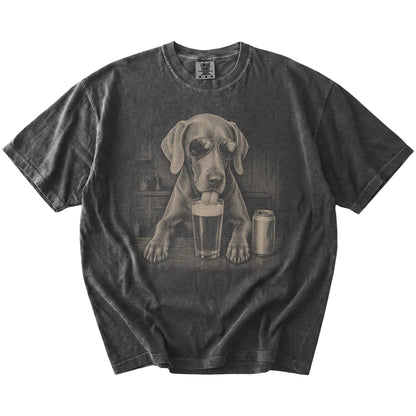 Weimaraner sneaking a drink from a foamy pint at home on a Pepper Comfort Colors® t-shirt