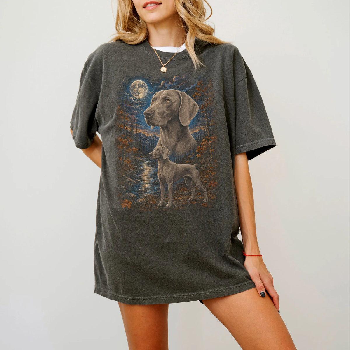 Model wearing a Pepper Comfort Colors® t-shirt featuring Weimaraner in a moonlit fall forest