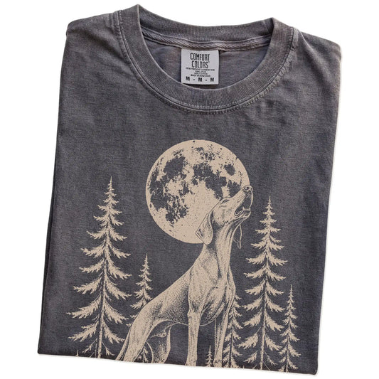 Folded Pepper Comfort Colors® T-shirt showing a Weimaraner howling beneath the moon and pine trees