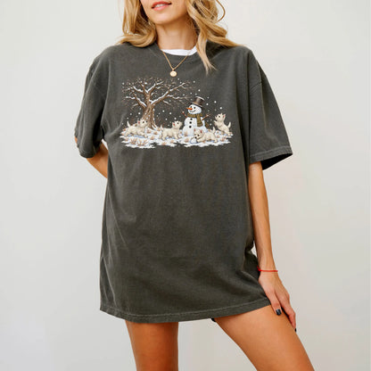 Westie puppies playing in snow with a snowman on a Pepper T-shirt worn by a model