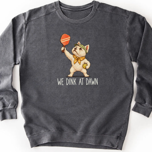 Westie with a pickleball paddle and ball on a Pepper Comfort Colors® sweatshirt with We Dink at Dawn text