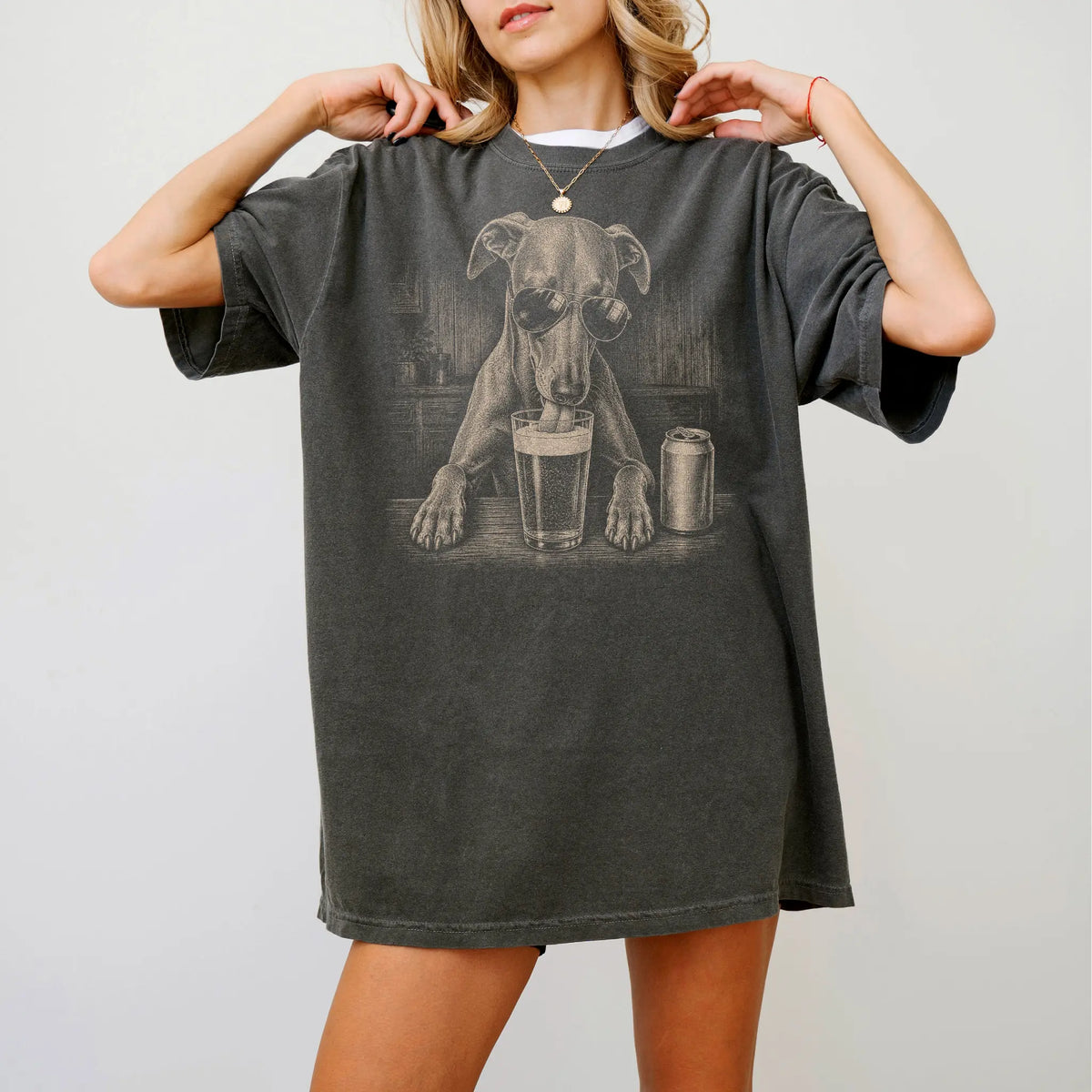 Model wearing a Pepper Comfort Colors® t-shirt with Whippet sneaking a drink from a pint