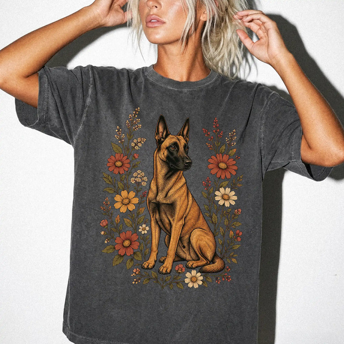 Model wearing a Pepper Comfort Colors® T-shirt showing Belgian Malinois portrait surrounded by wildflowers beneath the moon