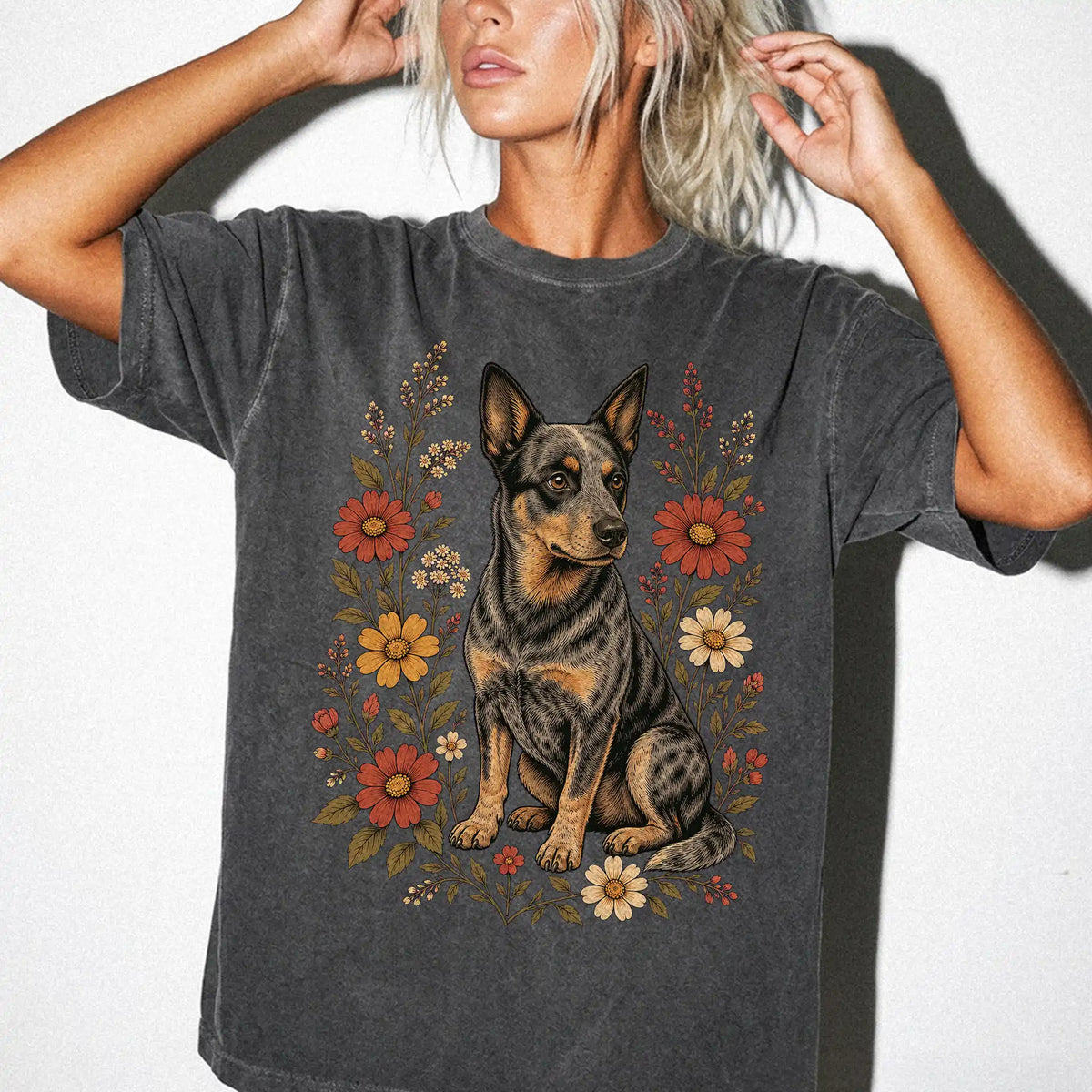 Model wearing a Pepper Comfort Colors® T-shirt showing Blue Heeler portrait surrounded by wildflowers beneath the moon