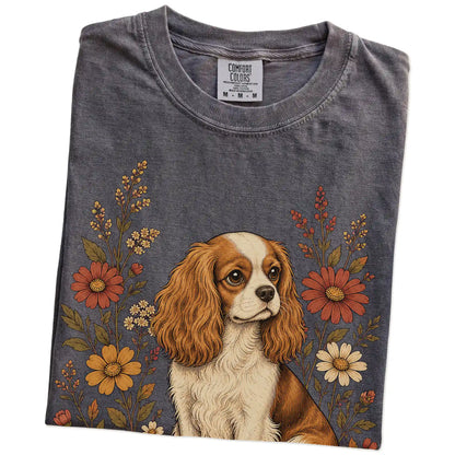 Folded Pepper Comfort Colors® T-shirt showing Cavalier King Charles Spaniel portrait surrounded by wildflowers beneath the mo