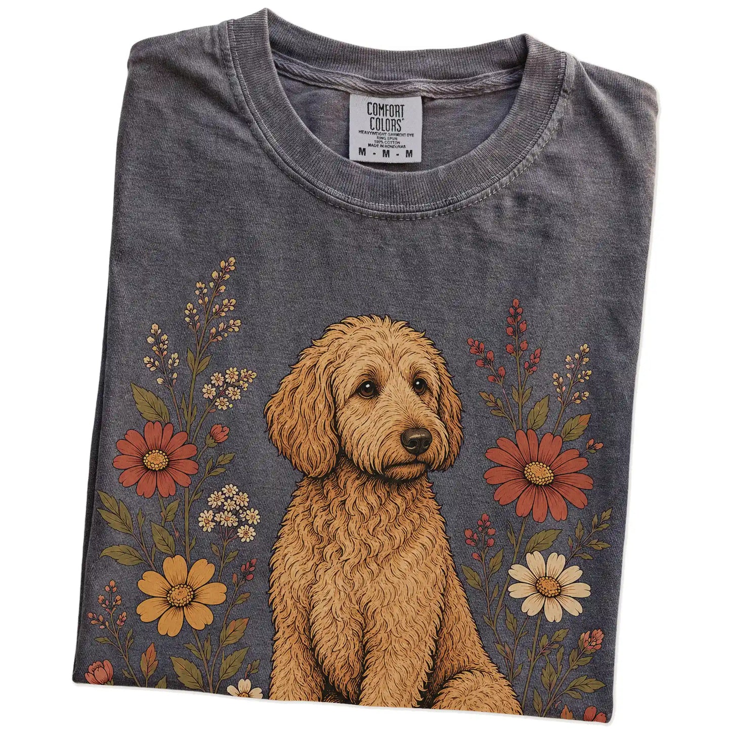 Folded Pepper Comfort Colors® T-shirt showing Goldendoodle portrait surrounded by wildflowers beneath the moon