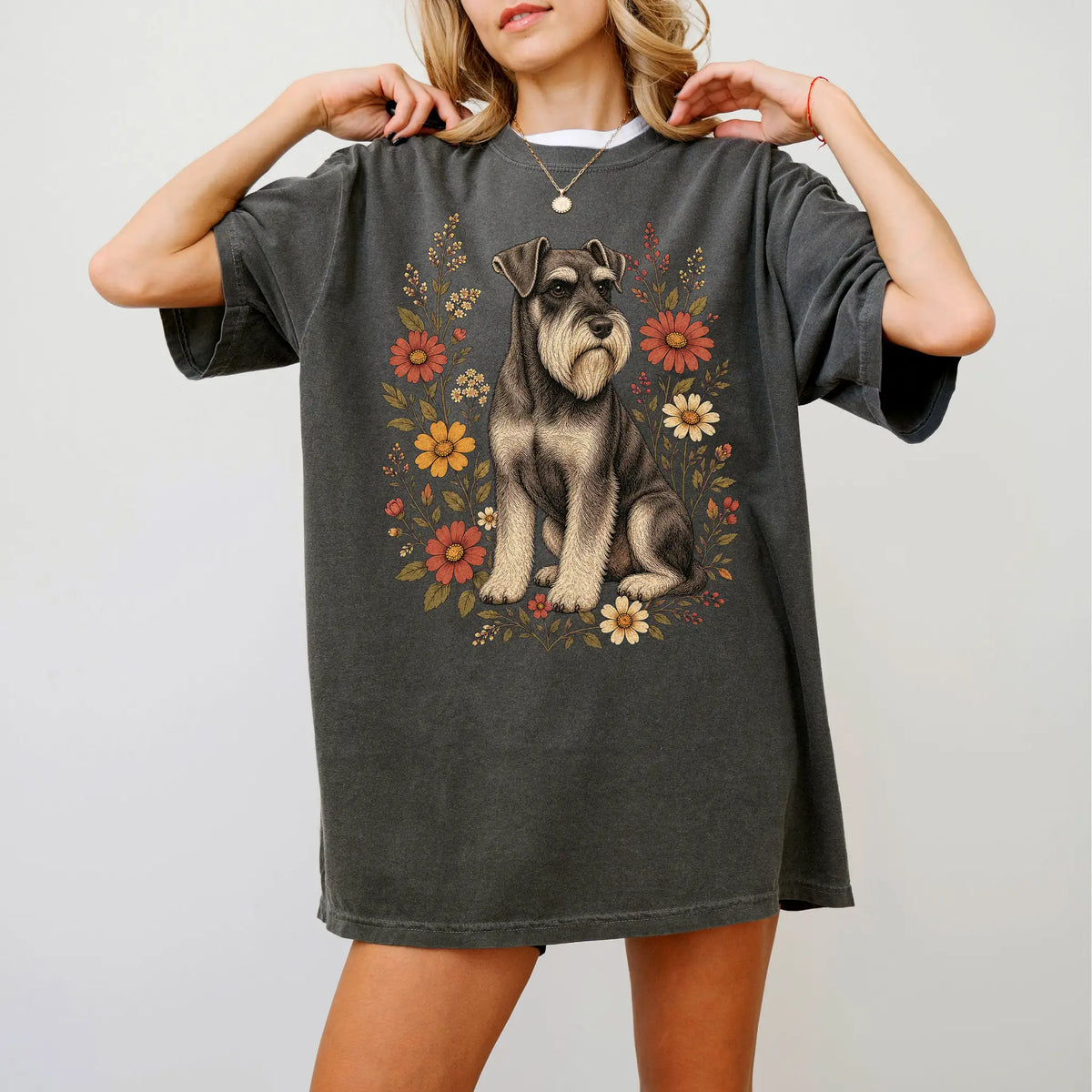 Model wearing a Pepper Comfort Colors® T-shirt showing Standard Schnauzer portrait surrounded by wildflowers beneath the moon