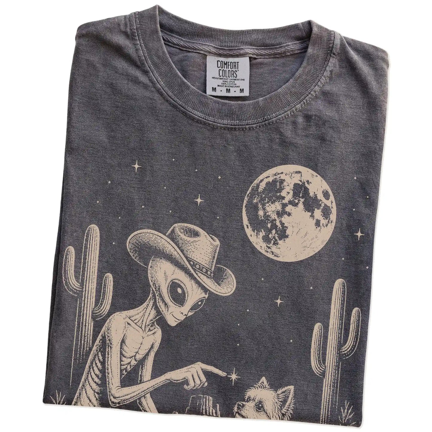 Folded Pepper Comfort Colors® T-shirt showing cowboy alien fist-bumping a yorkie beneath the moon