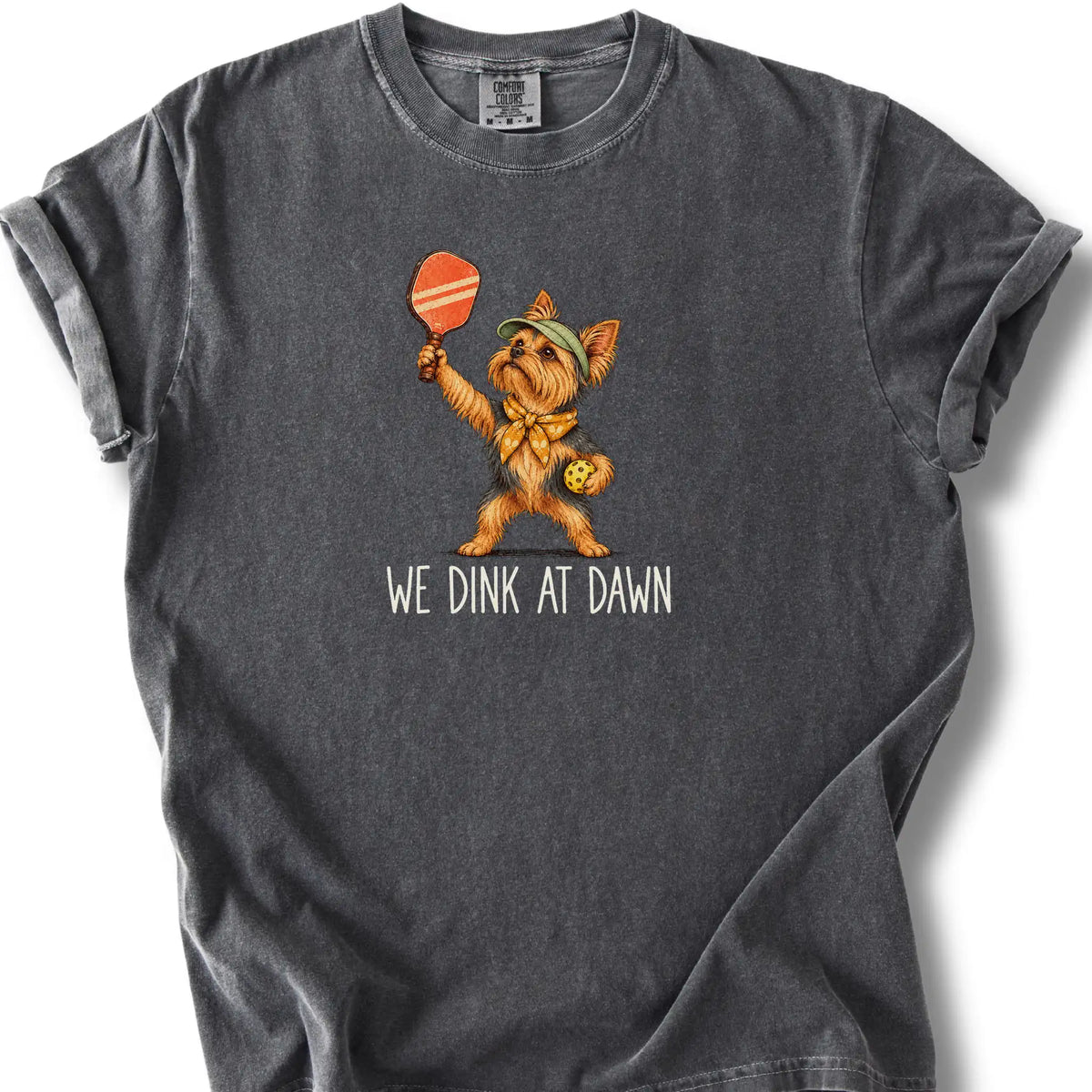 Yorkie with a pickleball paddle and ball on a Pepper Comfort Colors® T-shirt with We Dink at Dawn text