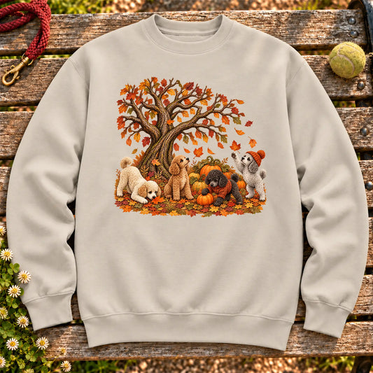 Four Poodle puppies with pumpkins beneath an autumn tree on a Sand crewneck sweatshirt