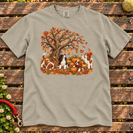 Four Cavalier King Charles Spaniel puppies with pumpkins beneath an autumn tree on a Sandstone garment-dyed T-shirt