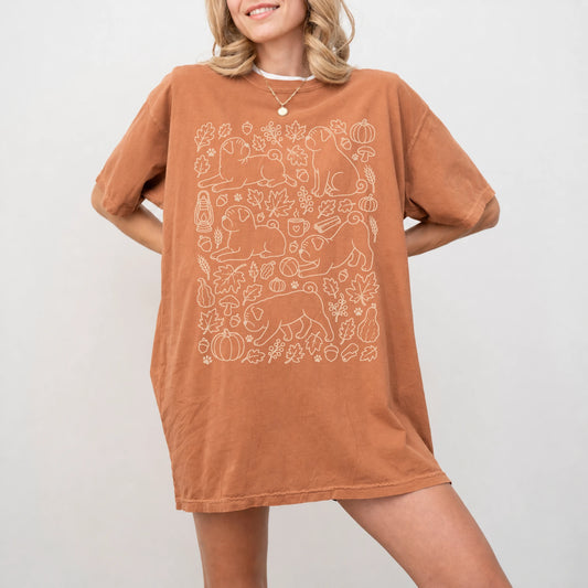 Model wearing a Yam Comfort Colors® T-shirt with Pug dogs with pumpkins, leaves, acorns, and woodland details