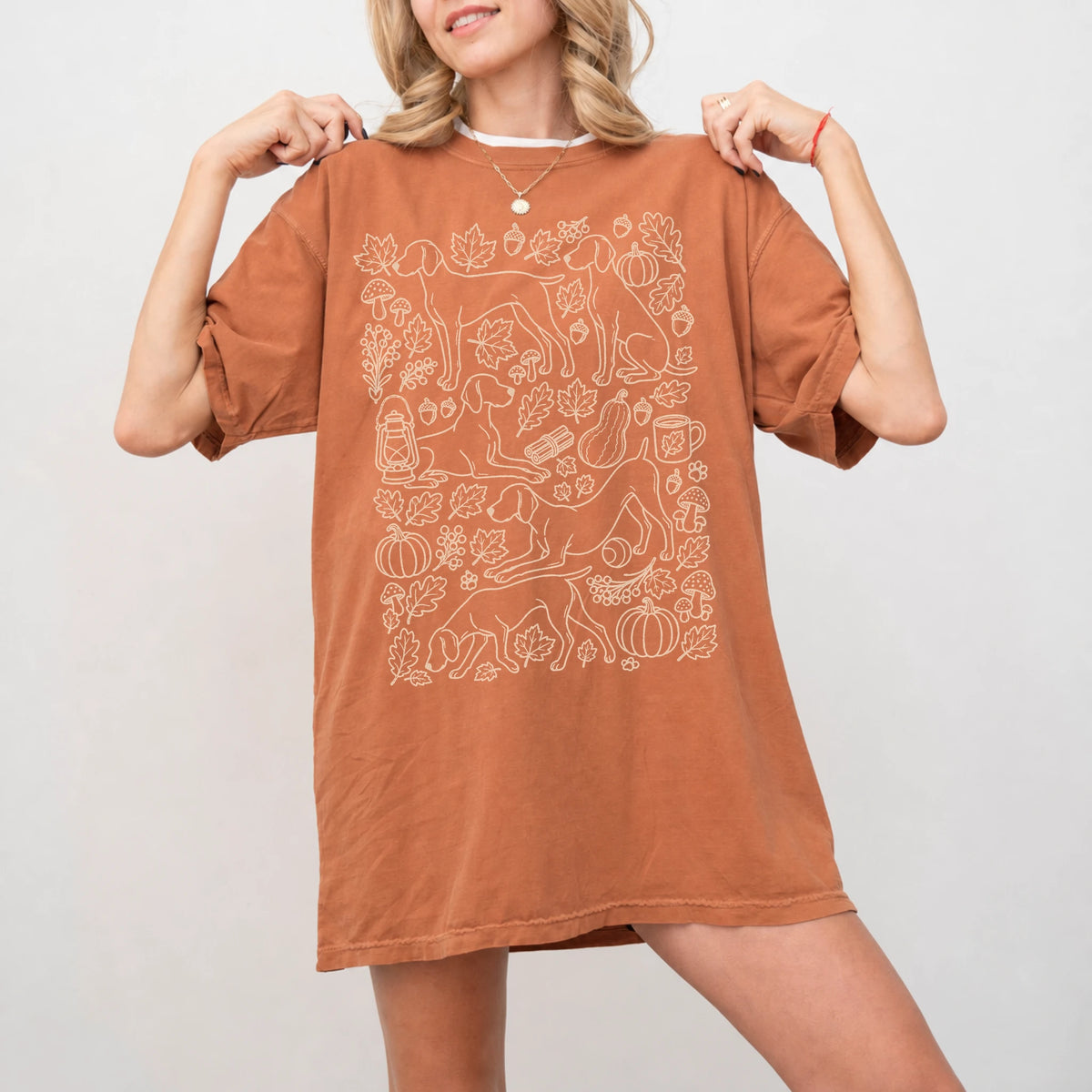 Model wearing a Yam Comfort Colors® T-shirt with Weimaraner dogs with pumpkins, leaves, acorns, and woodland details