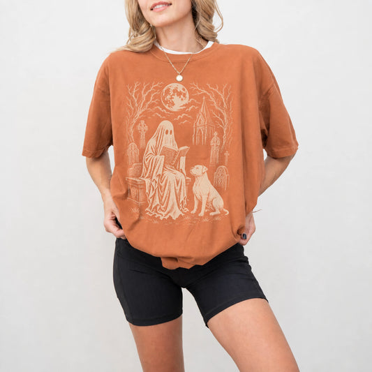Model wearing a Yam Comfort Colors® T-shirt showing American Bulldog beside a reading ghost in a moonlit graveyard
