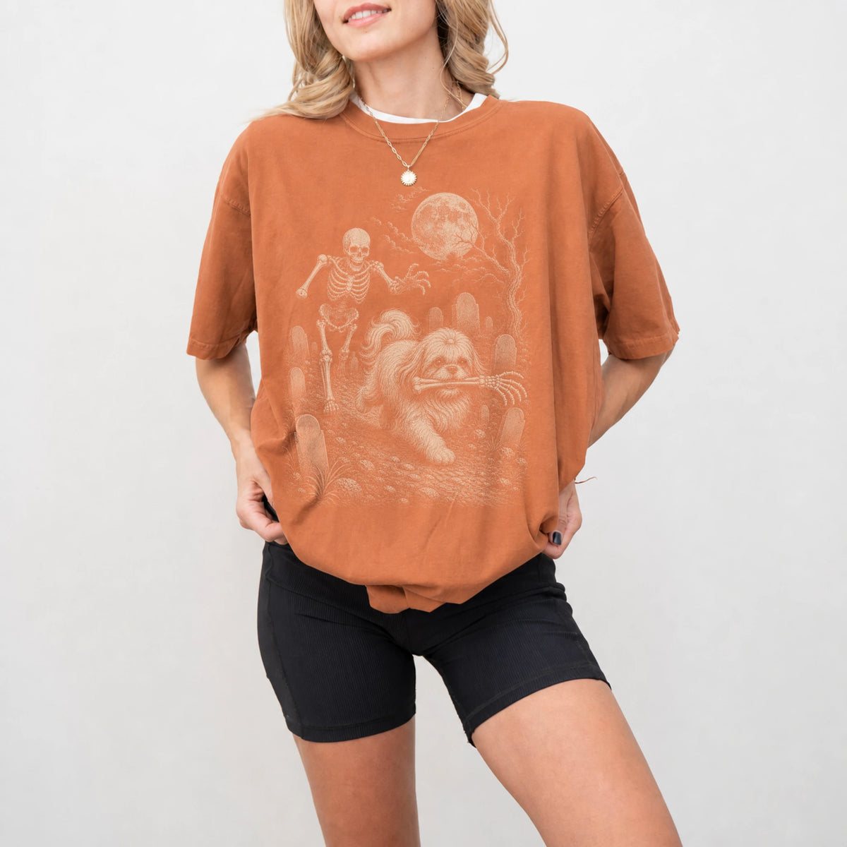 Model wearing a Yam Comfort Colors® T-shirt showing Shih Tzu running through a moonlit graveyard with a chasing skeleton