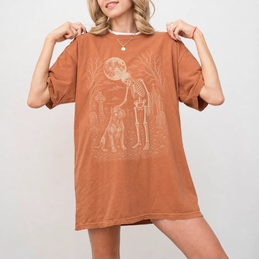 Model wearing a Yam Comfort Colors® T-shirt showing Cane Corso sharing a quiet cemetery moment with a friendly skeleton