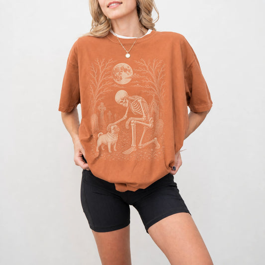 Model wearing a Yam Comfort Colors® T-shirt showing Pug sharing a quiet cemetery moment with a friendly skeleton