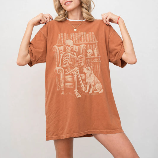 Model wearing a Yam Comfort Colors® T-shirt showing skeleton reading in a library beside a Blue Heeler