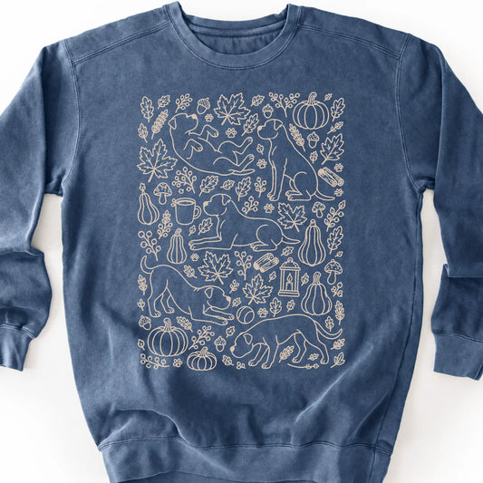 American Bulldog among autumn leaves and seasonal icons on a denim sweatshirt.