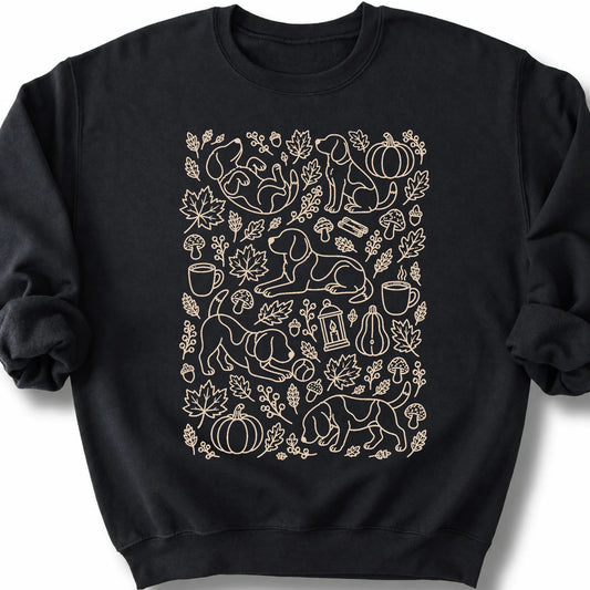Beagle among autumn leaves and seasonal icons on a black sweatshirt.