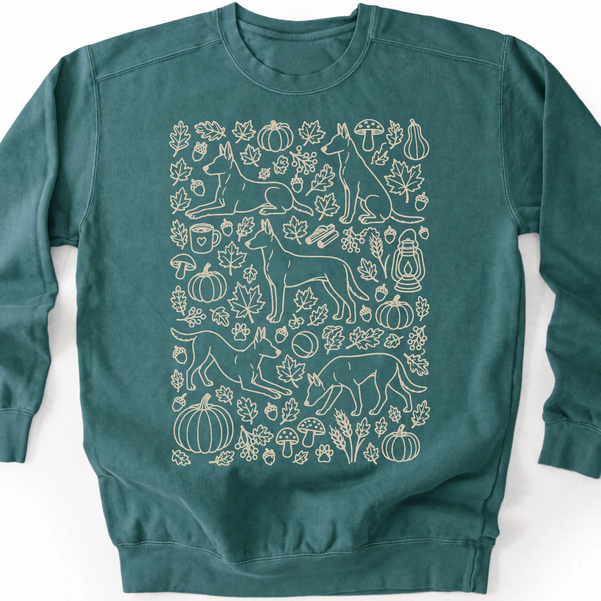 Belgian Malinois among autumn leaves and seasonal icons on a blue spruce sweatshirt.