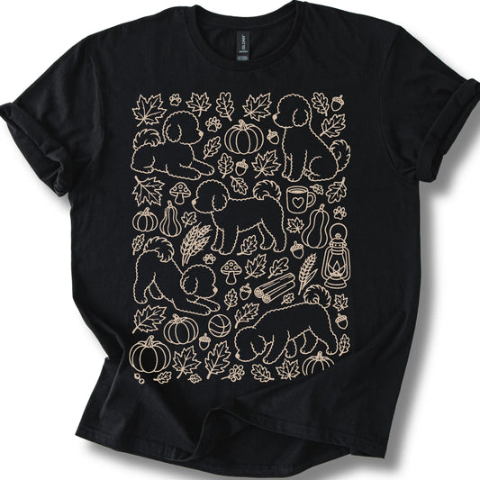 Bichon Frise among autumn leaves and seasonal icons on a black T-shirt.