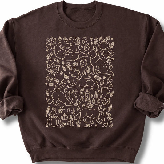 Border Collie among autumn leaves and seasonal icons on a dark chocolate sweatshirt.