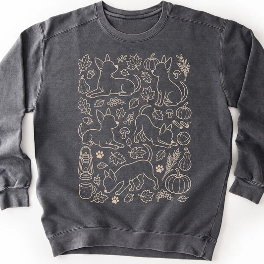 Chihuahua among autumn leaves and seasonal icons on a pepper sweatshirt.