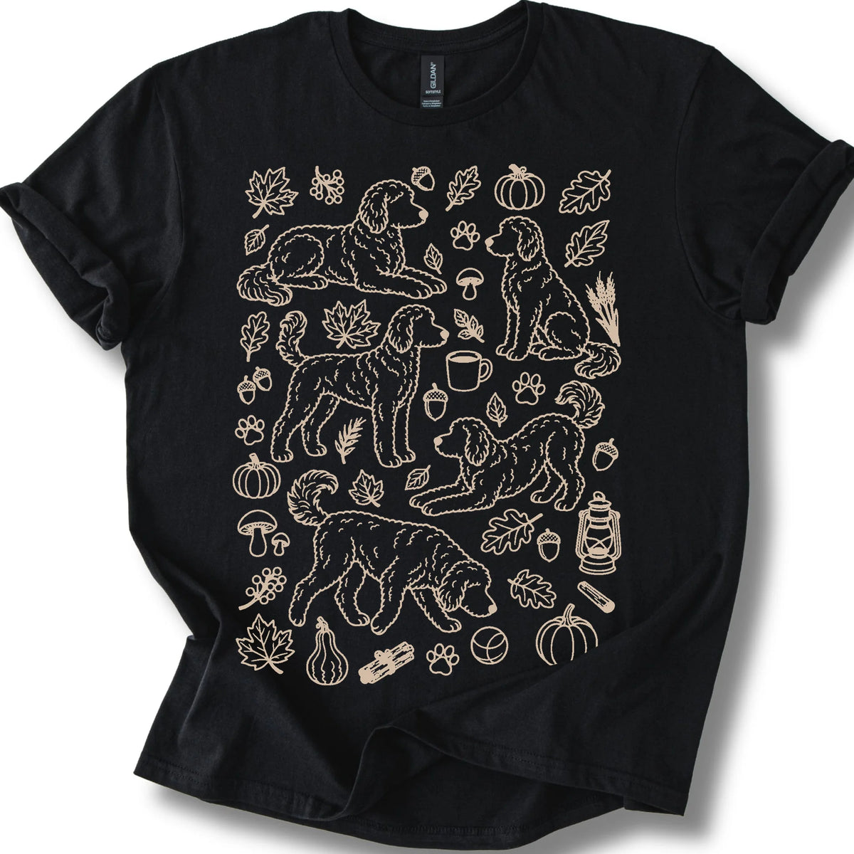 Goldendoodle among autumn leaves and seasonal icons on a black T-shirt.
