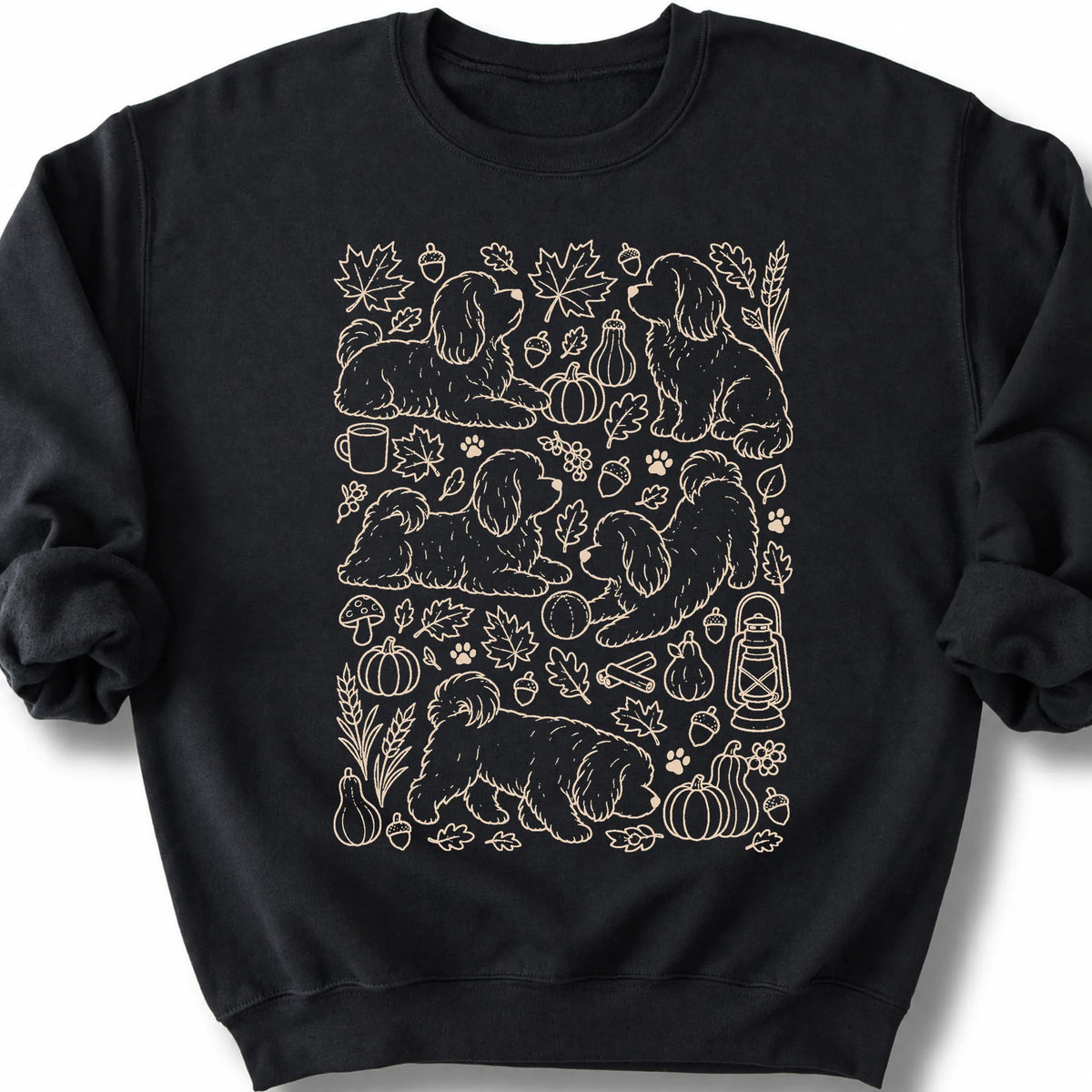 Havanese among autumn leaves and seasonal icons on a black sweatshirt.