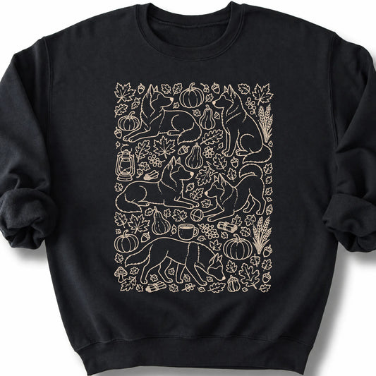 Husky among autumn leaves and seasonal icons on a black sweatshirt.