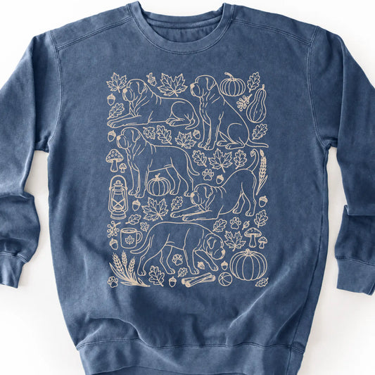 Mastiff among autumn leaves and seasonal icons on a denim sweatshirt.