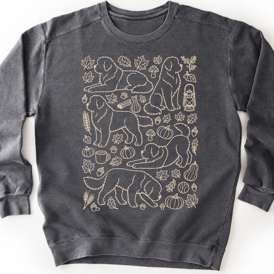 Newfie among autumn leaves and seasonal icons on a pepper sweatshirt.