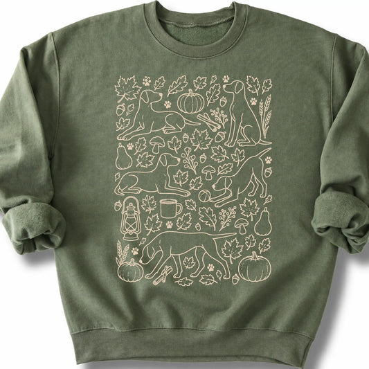 Pointer among autumn leaves and seasonal icons on a military green sweatshirt.