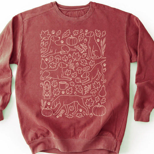 Pointer among autumn leaves and seasonal icons on a crimson sweatshirt.