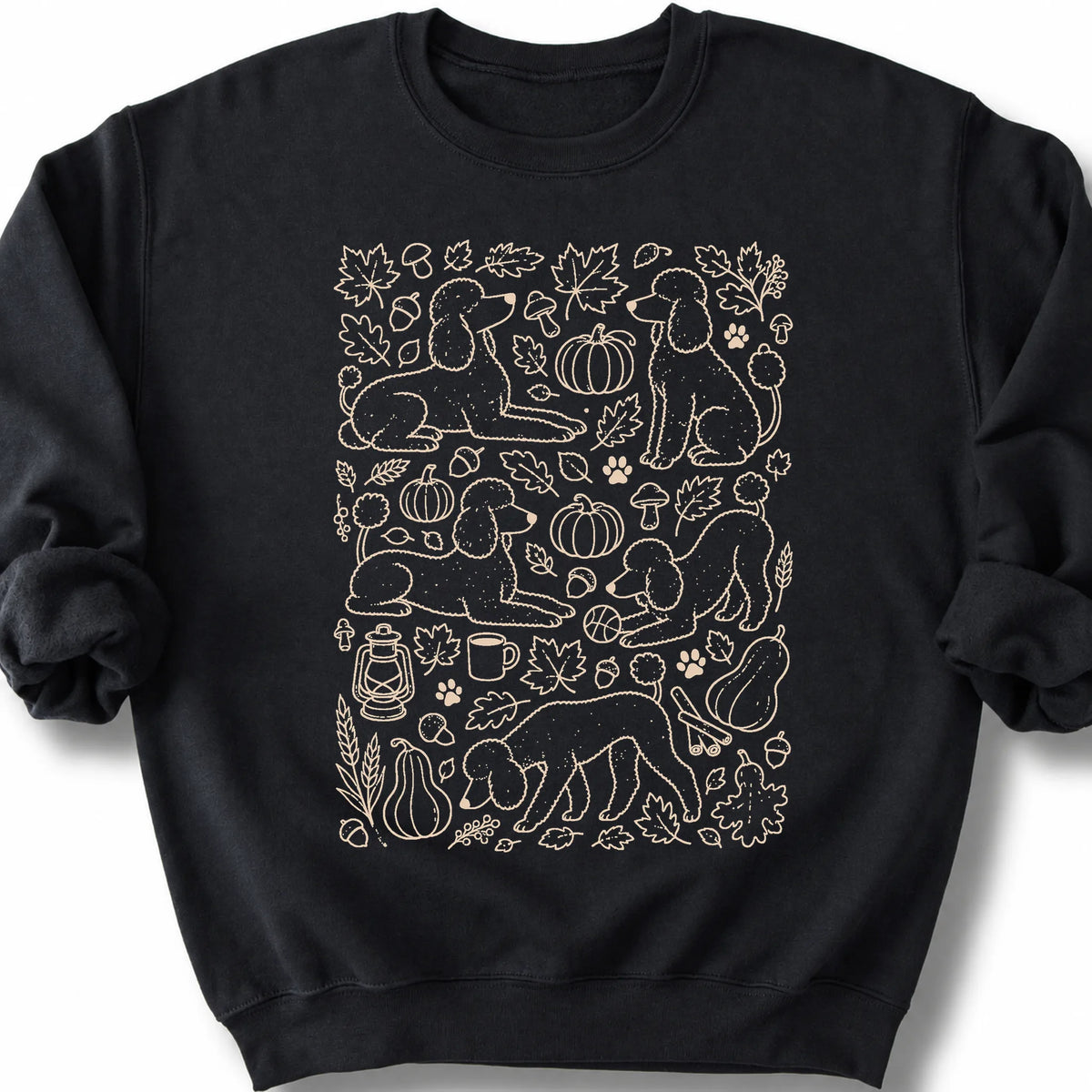 Poodle among autumn leaves and seasonal icons on a black sweatshirt.