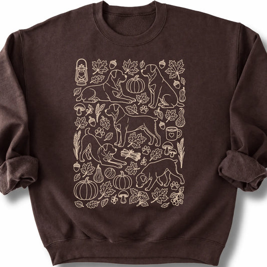 Rottweiler among autumn leaves and seasonal icons on a dark chocolate sweatshirt.