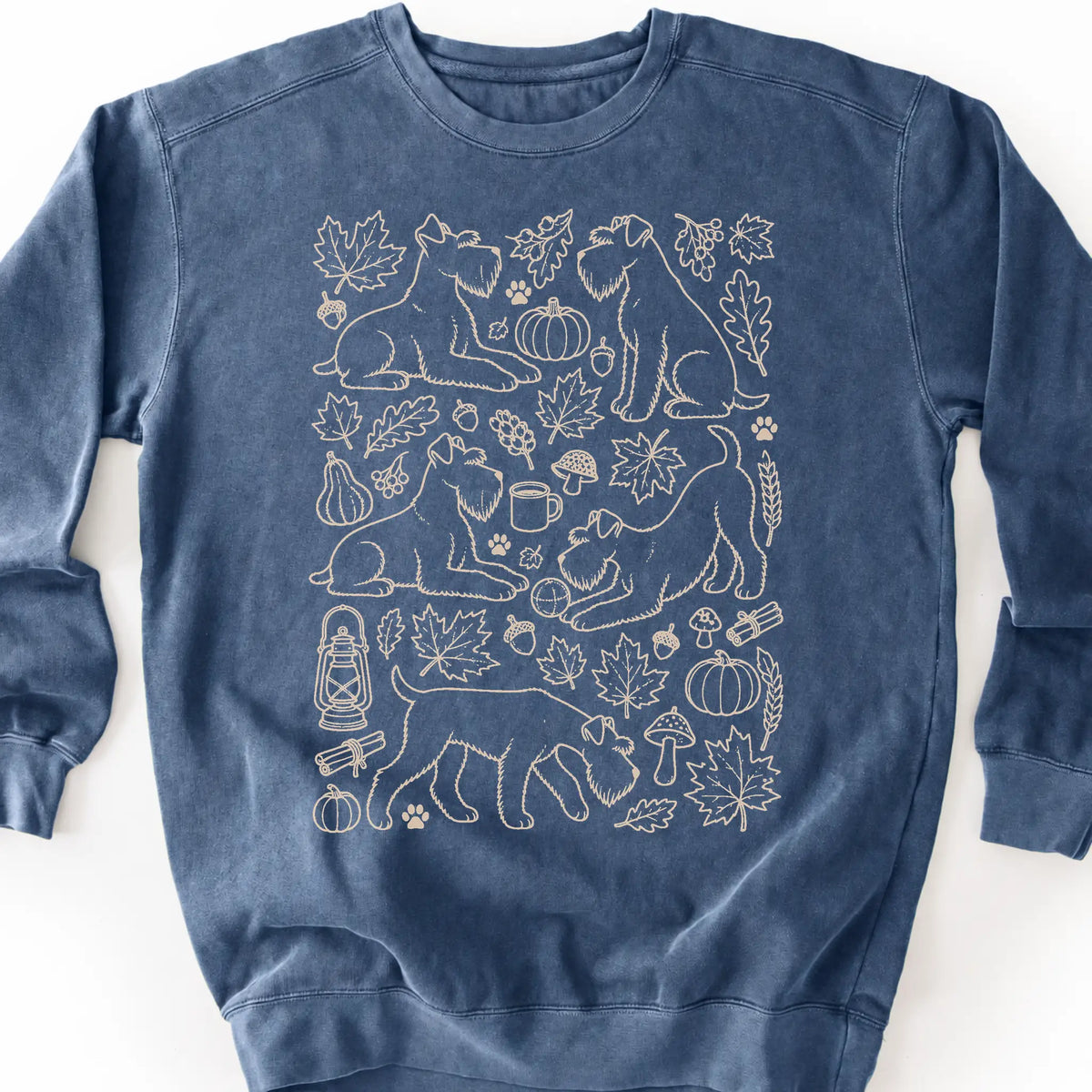 Standard Schnauzer among autumn leaves and seasonal icons on a denim sweatshirt.