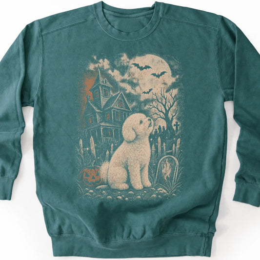 Bichon Frise beside a haunted house on a blue spruce sweatshirt.
