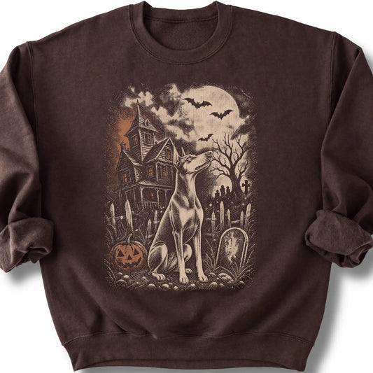 Doberman beside a haunted house on a dark chocolate sweatshirt.