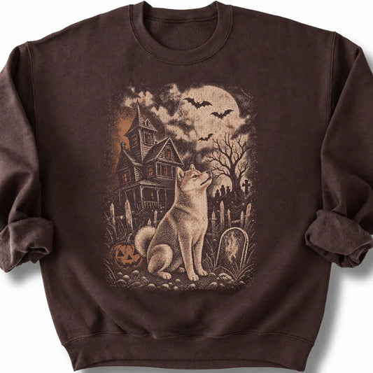 Shiba Inu beside a haunted house on a dark chocolate sweatshirt.