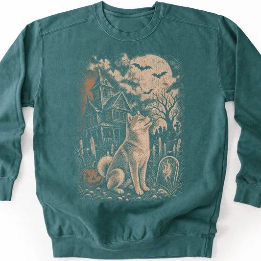 Shiba Inu beside a haunted house on a blue spruce sweatshirt.