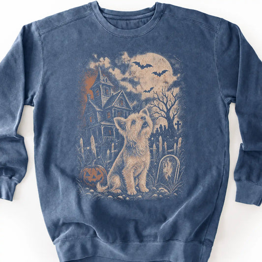 Yorkie beside a haunted house on a denim sweatshirt.
